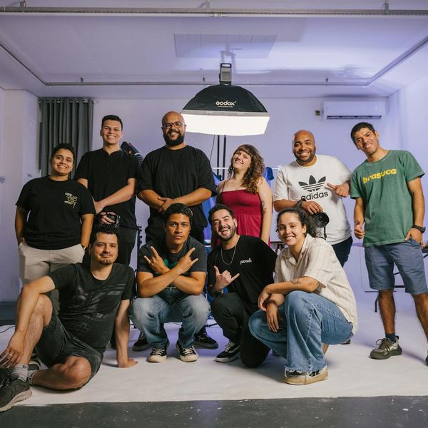 A diverse group of people smiling and looking relaxed in a bright studio.