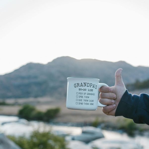 Person stretching gracefully outdoors with the sun setting behind them.